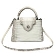 White Alligator skin handbag with a strap on a gray background