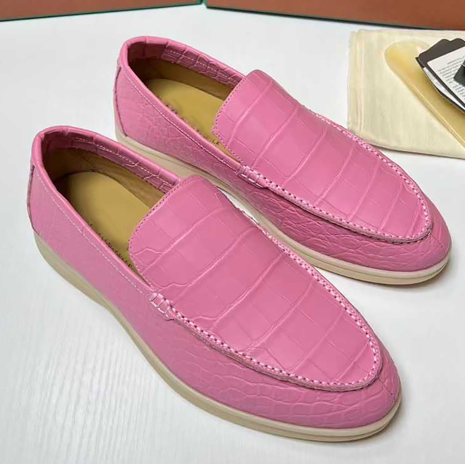 Pink loafers with a textured pattern on a light surface