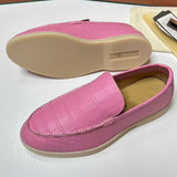Pink loafers with a textured pattern on a white surface